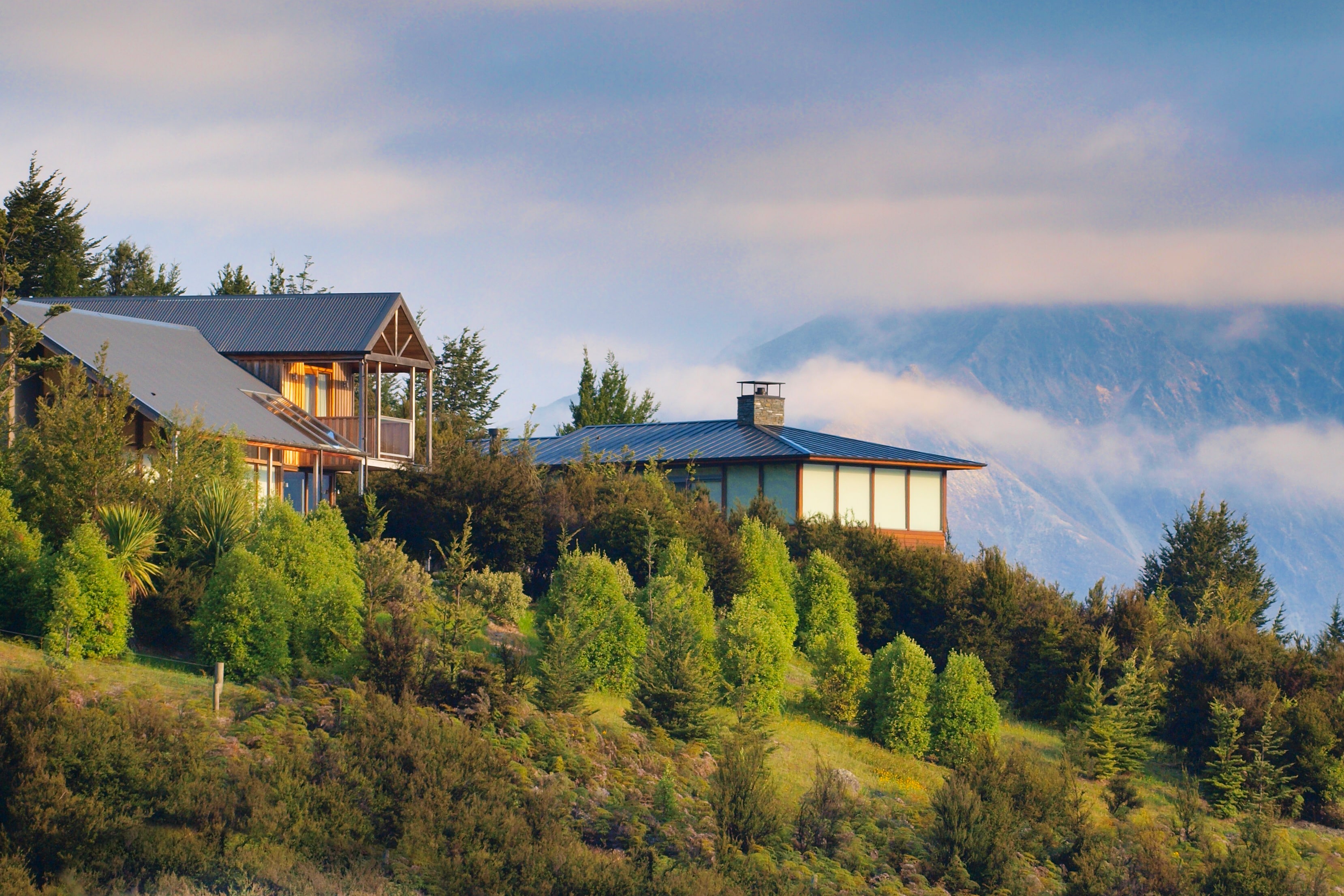 A hilltop modern chalet home with misty mountains in the background, managed by Scheele Property Management